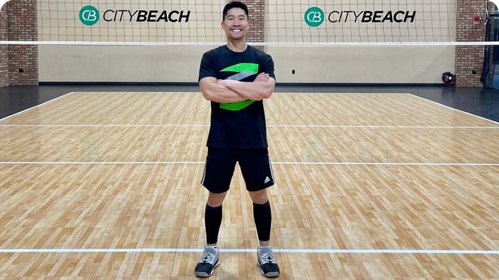 Coach Donny Hui, volleyball coach and performance trainer, on an indoor volleyball court.