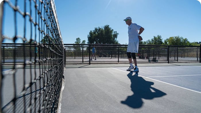Pickleball player demonstrates balance, proprioception, and the effects of proprioception and aging on an outdoor court.