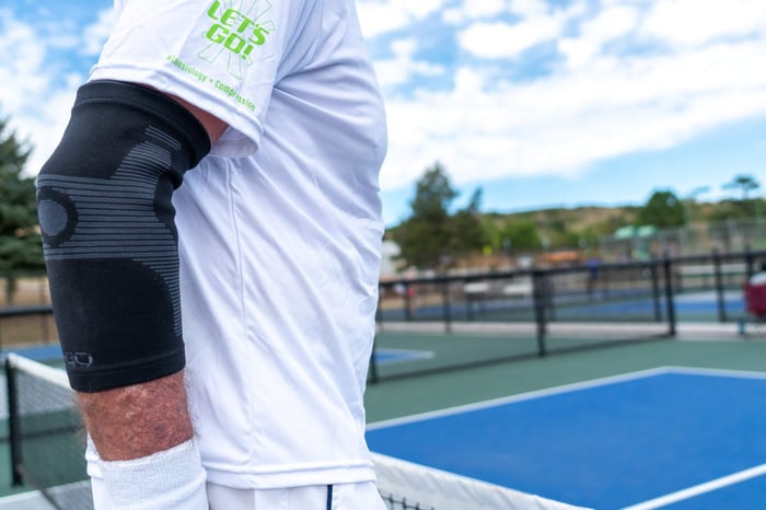 NBA Hall of Famer Rick Barry playing pickleball while wearing a GO Sleeves elbow sleeve.