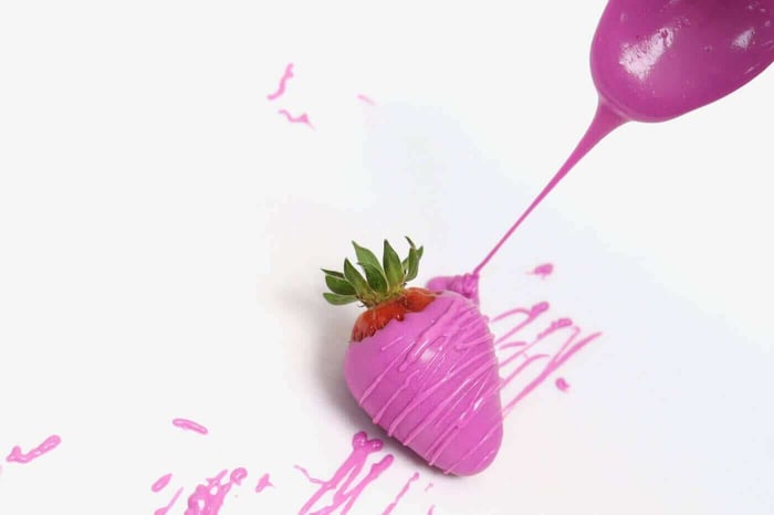 drizzling chocolate on edible glitter strawberry