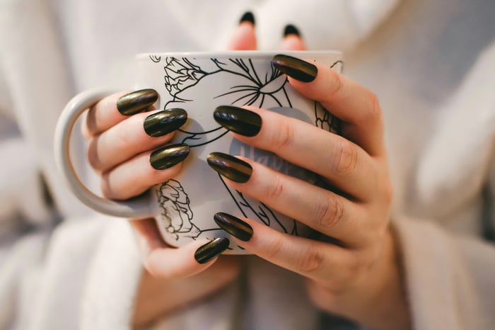 woman holding floral-themed cup
