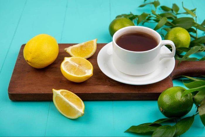 fresh lemons on wood kitchen board with a cup of coffee