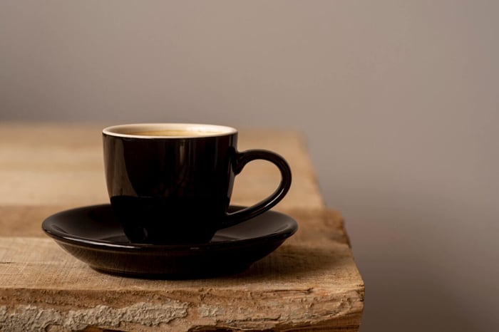 hot coffee cup on wooden table front view.