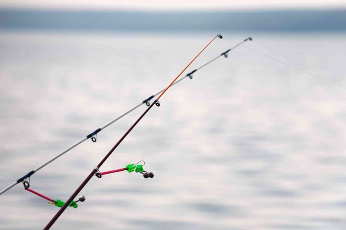 Angler holding a spinning reel with bright fishing line – braided line vs mono selection in action.