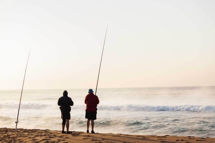 Two people surf fishing