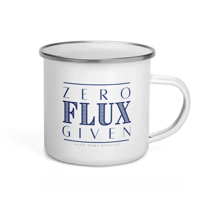 Enamel mug featuring the phrase 'Zero Flux Given' in bold lettering, designed by artisan jeweler Allie Perry. The mug has a glossy finish and a classic shape, making it perfect for enjoying hot beverages while adding a touch of humor to the jewelry-making workspace.