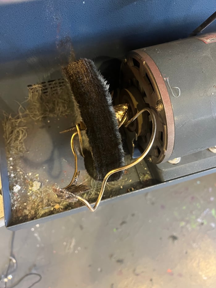 A polishing machine that has a piece of jewelry wrapped around it.