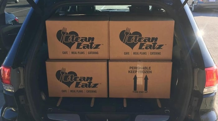 healthy meal plan delivery with Clean Eatz branded boxes packed in a car trunk ready for transport or delivery