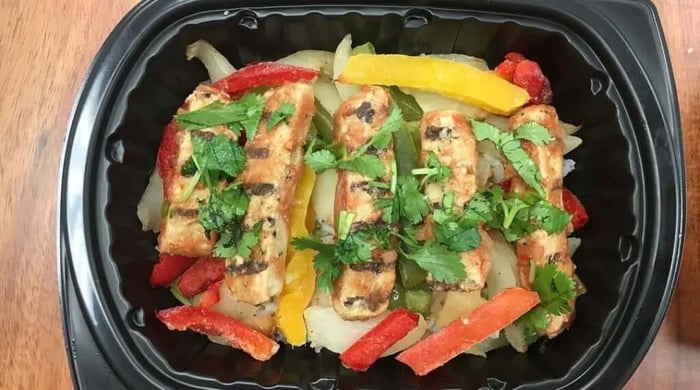 Balanced meal ideas featuring grilled chicken strips with peppers and onions, topped with cilantro in a meal prep tray.