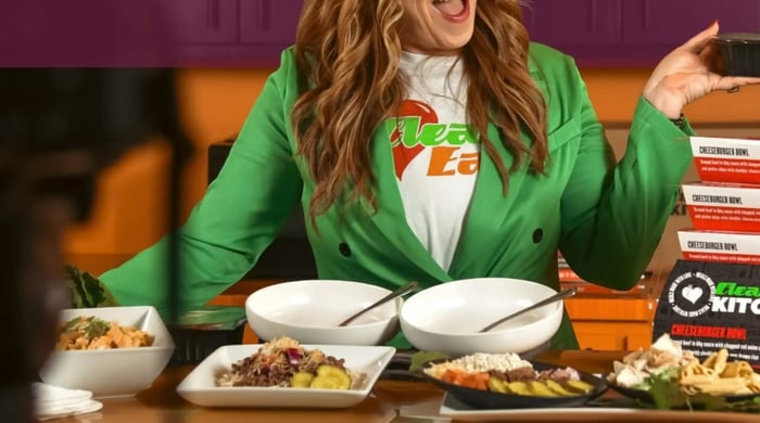 clean eating meal prep with plated healthy meals as a woman presents multiple prepared dishes in a colorful kitchen