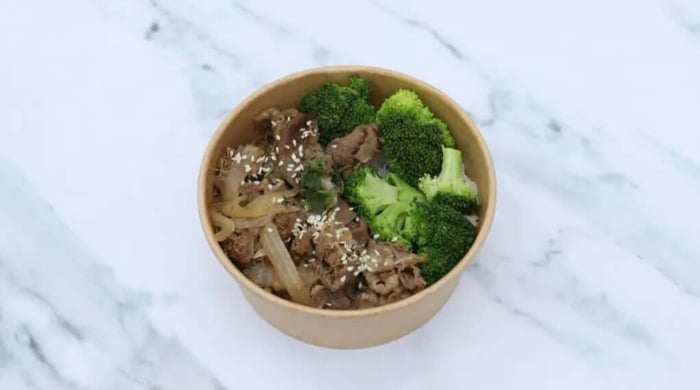 Healthy meals made easy with a takeout bowl of sliced beef, broccoli, onions, and sesame seeds over rice.