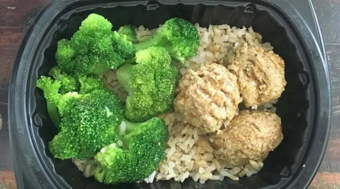 High-protein meal of turkey meatballs over brown rice with steamed broccoli in a Clean Eatz Kitchen container.