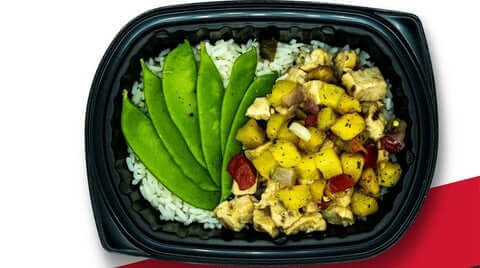 High protein meal prep teriyaki pineapple chicken with rice, snap peas, and pineapple salsa in black container.
