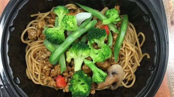 Macro-friendly meal of beef and broccoli lo mein with mushrooms and green beans served in a Clean Eatz Kitchen container.