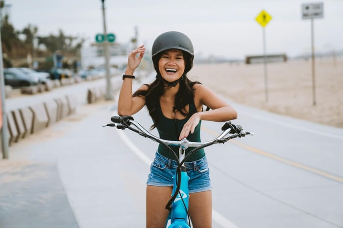 girl on a bicycle next to the beach