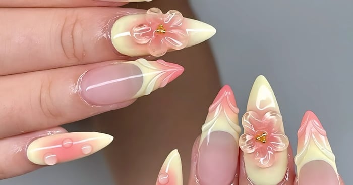 Clear 3D designs sitting on top of pastel ombre nail colors that transition from a dark pink to a very pale yellow.