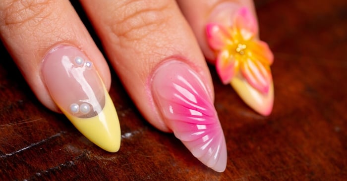 A close-up view of a person's nails, with professionally-done designs using 3D sculpt and pastel colors.