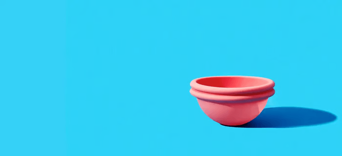 Pink menstrual disc against blue background