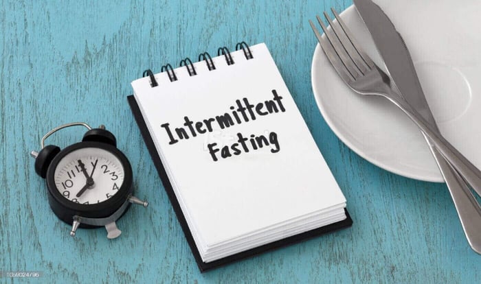 Person practicing fasting with healthy foods and time-restricted eating schedule showing the benefits of intermittent fasting for health and longevity