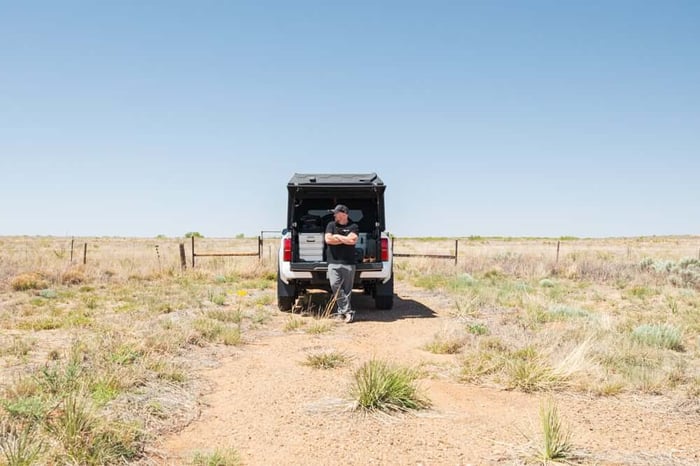 Alu-Cab ModCAP Tailgate truck camper parked roadside in a prarie.