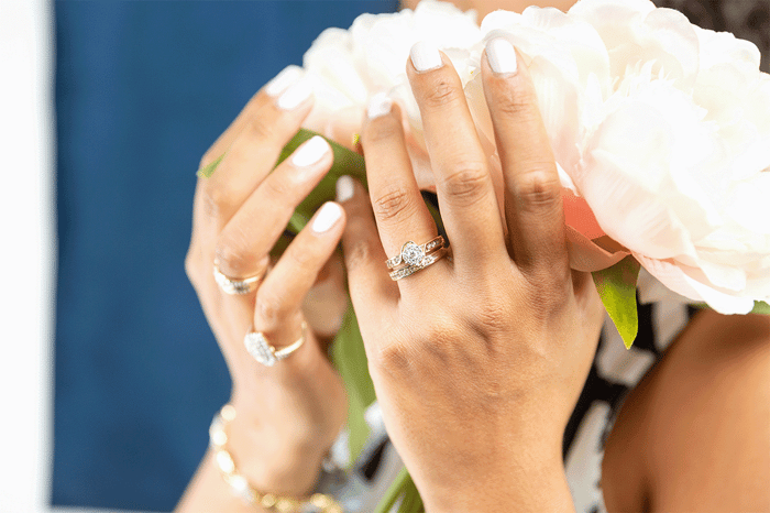 Woman with silver rings holding pink flowers