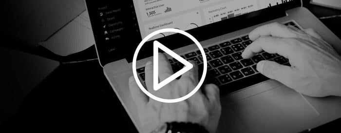 Hands typing on a laptop with a video play icon, representing playback of proprietary video formats