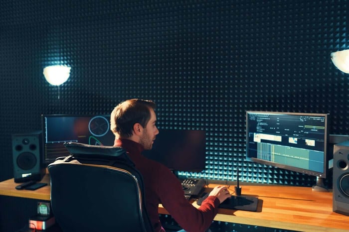 Technician at an audio and video editing workstation in a studio, beginning a video redaction project