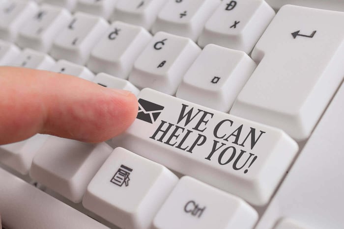 Finger pressing a keyboard key reading We Can Help You, representing help with time consuming redaction work