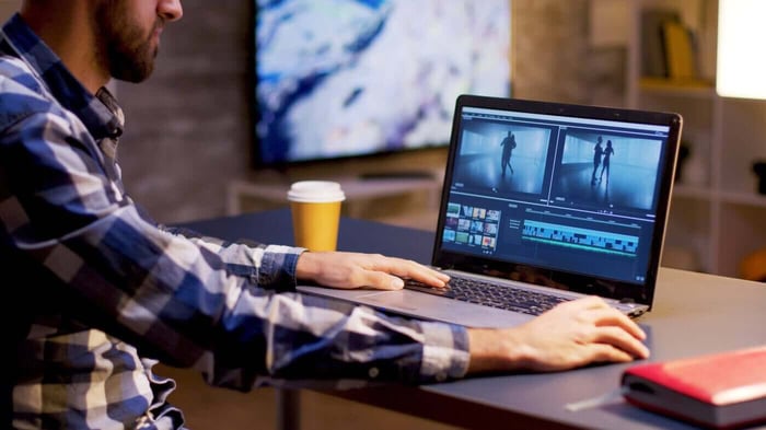 Person editing video on a laptop, representing the in house labor cost of video redaction
