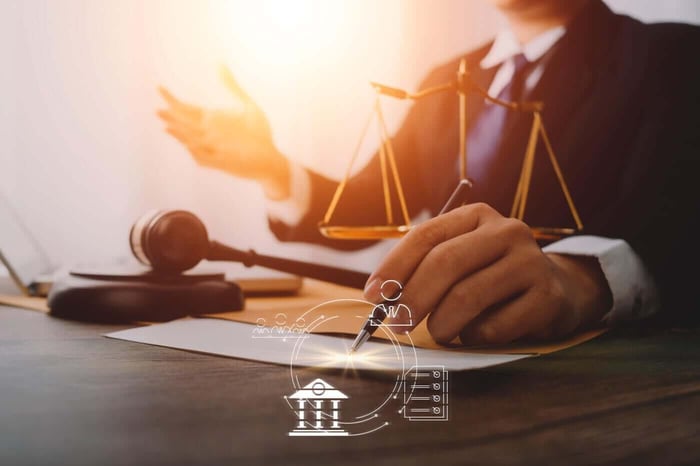 Scales of justice and a gavel on a desk, representing legal proceedings that rely on recorded audio and video evidence