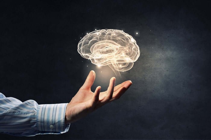 Glowing illustration of a brain above an open hand, representing reviewer mental health in redaction work