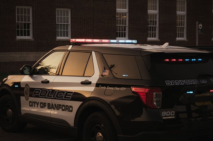 US municipal police SUV parked outside a station, the kind of agency now updating body worn camera policy under new body camera redaction laws