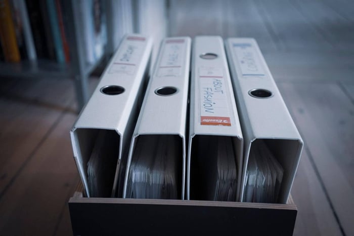 Row of black binders on a shelf representing the redaction logs and chain of custody records that support defensible video redaction