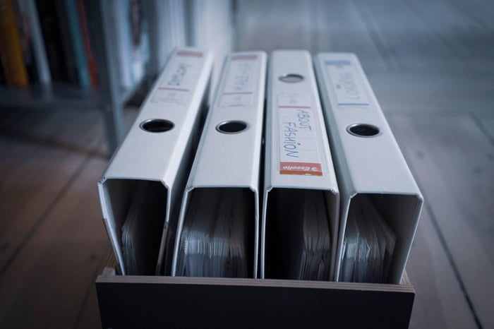Row of black binders on a shelf representing the redaction logs and chain of custody records that support defensible video redaction