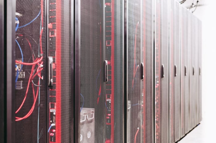 Row of server racks with cabling in a secure data center, representing where a video redaction company should store agency footage