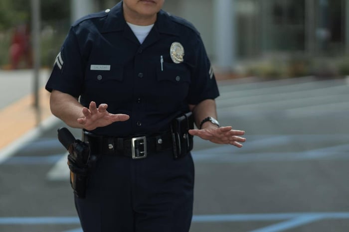 Colorado police officer in uniform standing on duty, representing the body camera footage subject to Colorado body camera records law release and blurring requirements