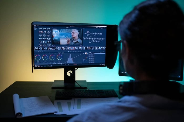 Editor reviewing redacted body camera footage over the shoulder on a wide monitor during a quality control pass