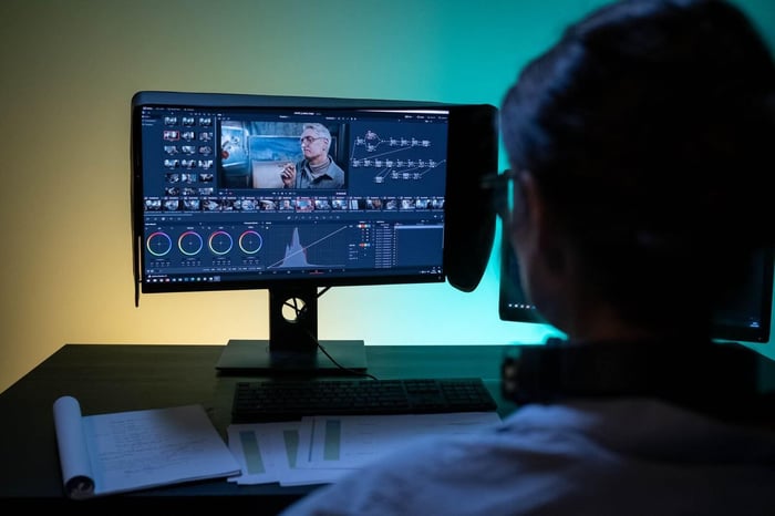 Editor reviewing redacted body camera footage over the shoulder on a wide monitor during a quality control pass