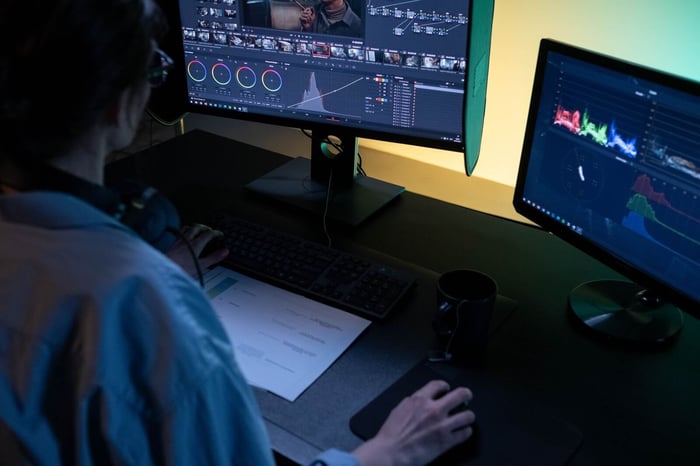 Examiner reviewing video on dual monitors with analysis scopes displayed, representing forensic video authentication