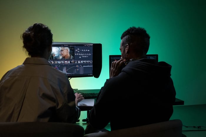 Two video redaction company reviewers checking footage together at a monitor during a quality control pass