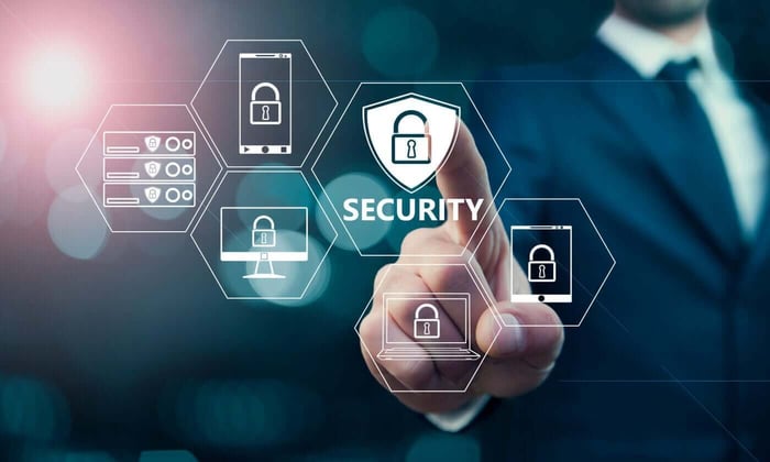 Hand touching a glowing security shield icon, representing data protection safeguards in video redaction services