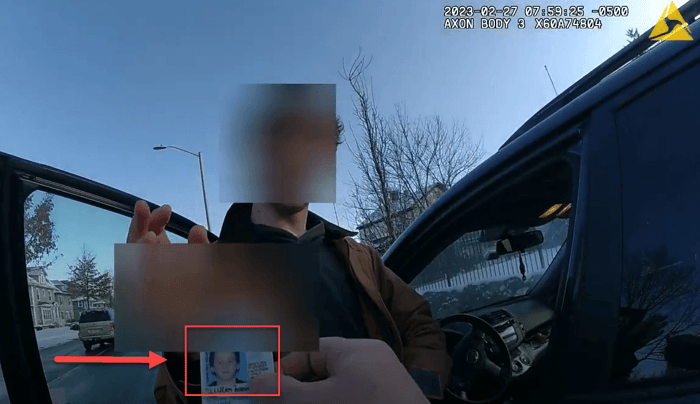 Body worn camera frame where a redaction mask slipped and exposed an identification card at a vehicle window