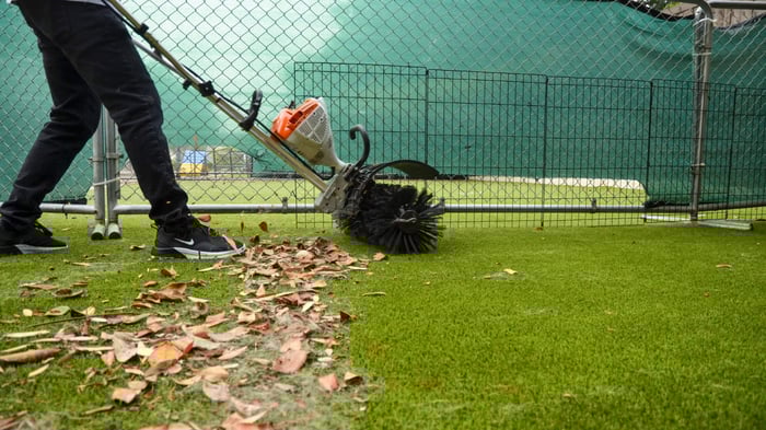 A man cleaning an artificial turf