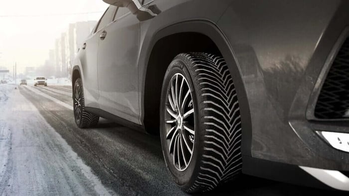FRight side of an SUV wearing Michelin Crossclimate 2 tires on a semi-snowy road