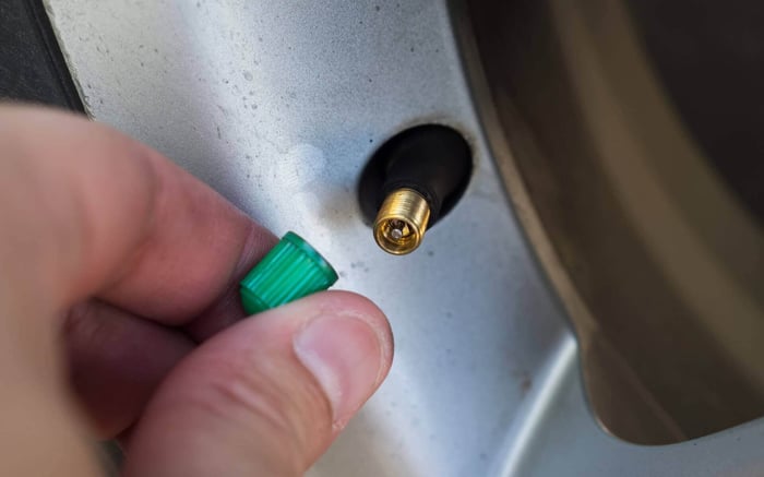 Gros plan d'une valve de pneu sur le point d'être vissée
