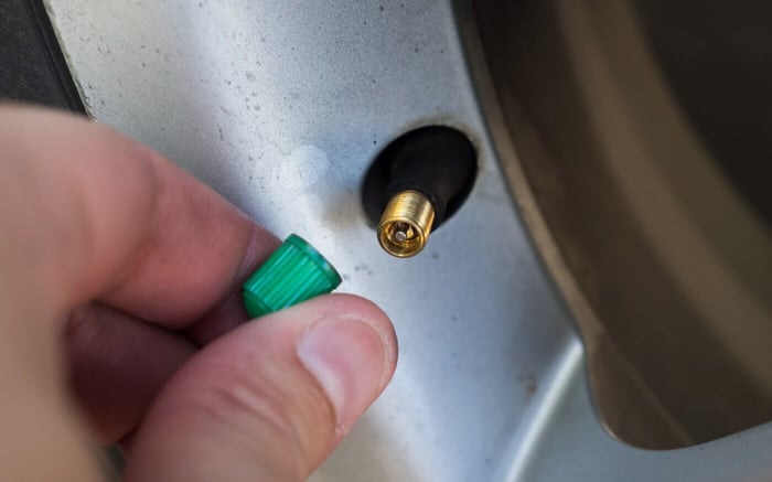 Main placant le bouchon sur la valve de pneu à l'azote