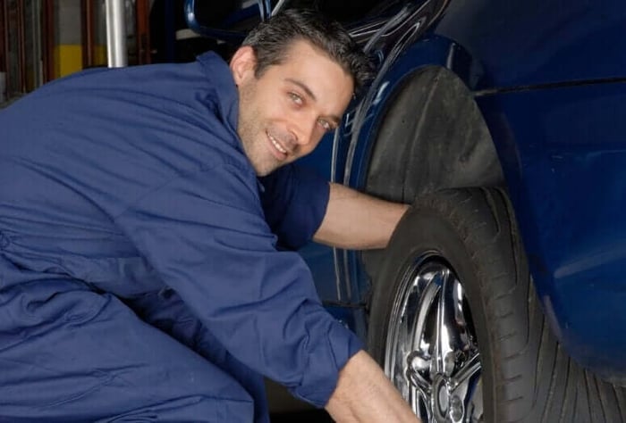 Un mécanicien au point d'aligner la roue d'une voiture