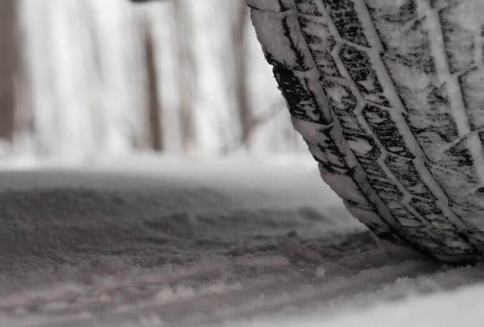 Plan rapproché d'un pneu d'hiver roulant sur la neige en toute sécurité