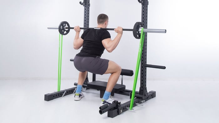 Kniebeugen mit Langhantelstange am Squat Rack