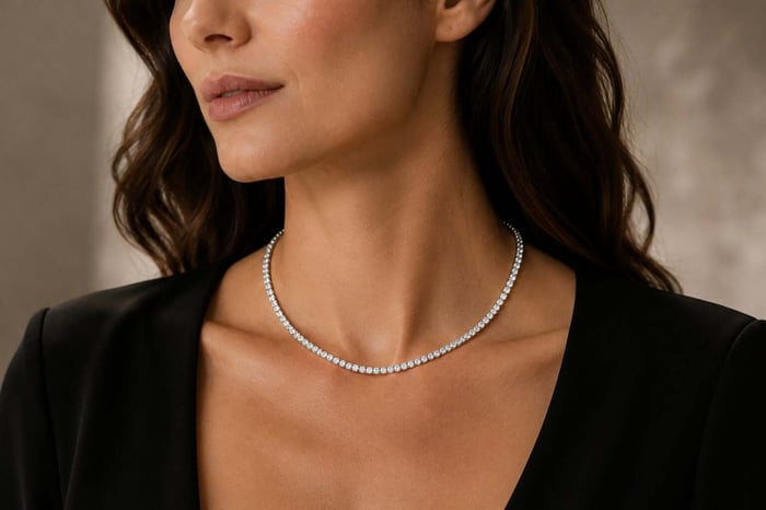 Woman wearing a 17-inch white-metal tennis necklace with a continuous line of small round white diamonds